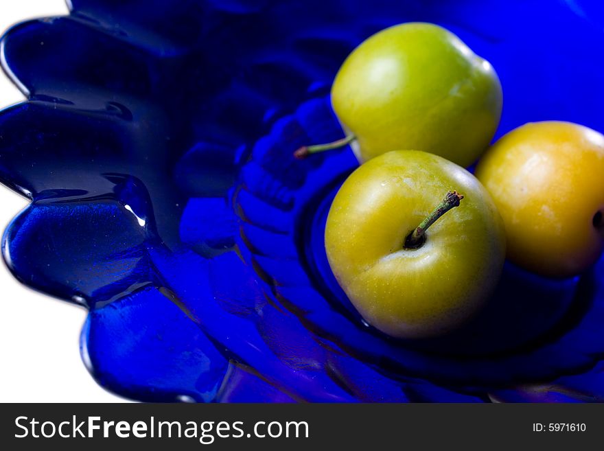 Group of plums on blue glass plate. Group of plums on blue glass plate