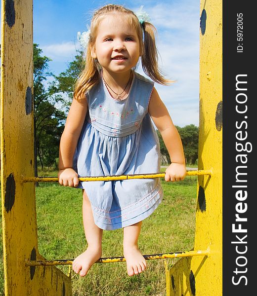 A girl plays in child's park, gymnastic stair. A girl plays in child's park, gymnastic stair