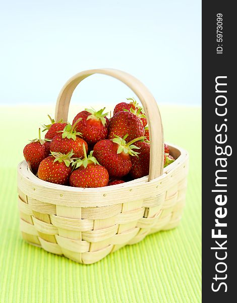Basket filled with strawberries over lime taple top. Basket filled with strawberries over lime taple top.