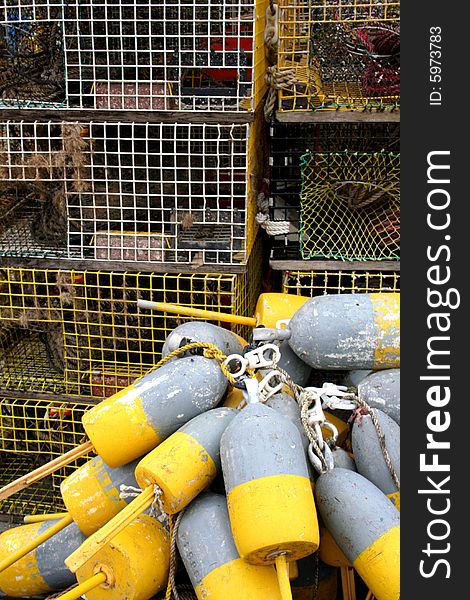 Lobster traps and buoys piled on a pier.