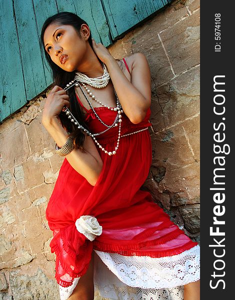 Fashion photo of filipino woman against barn wall