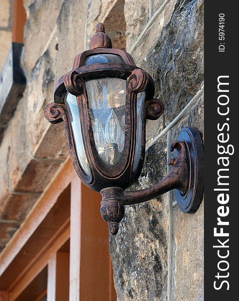 Decorative lamp on a stone faced building. Decorative lamp on a stone faced building