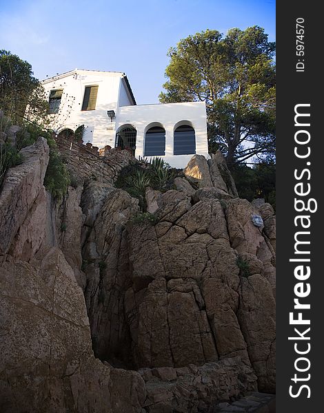 Cliff top Mediterranean beach-side holiday home catches the late afternoon sun