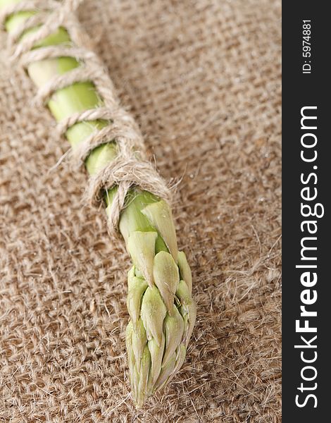 Fresh asparagus tied with rustic string on hessian rag for background, shallow DOF. Fresh asparagus tied with rustic string on hessian rag for background, shallow DOF