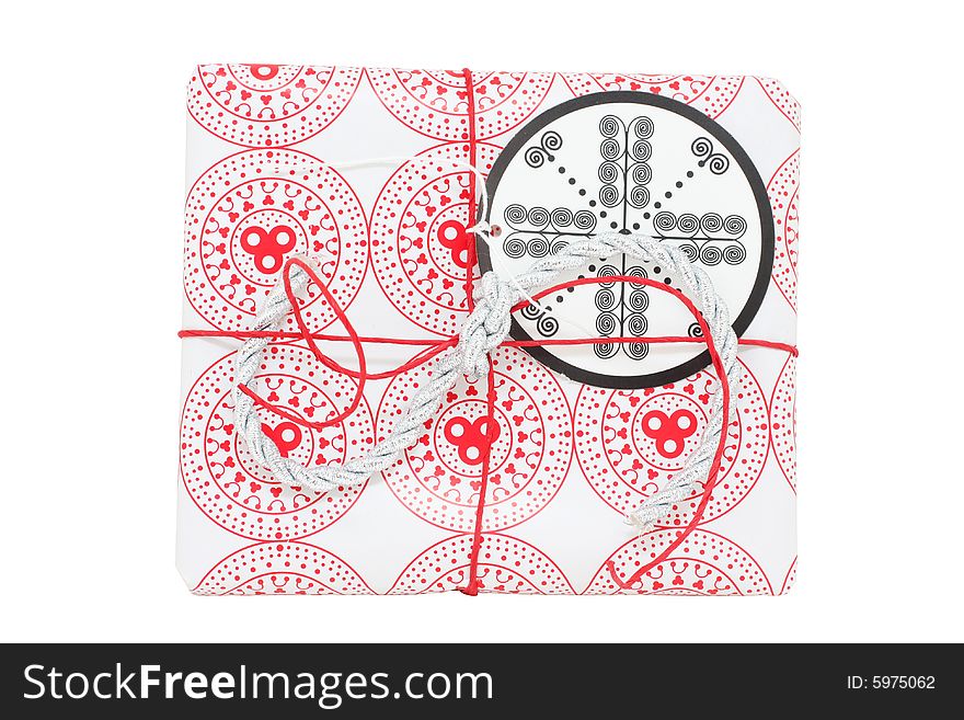 A gift wrapped in red and white paper, with gift tag, isolated on white. A gift wrapped in red and white paper, with gift tag, isolated on white