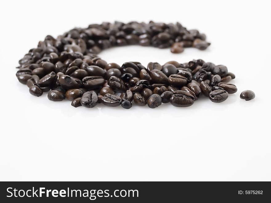 Closeup shot of coffee beans against white background with Tarragon herb on top