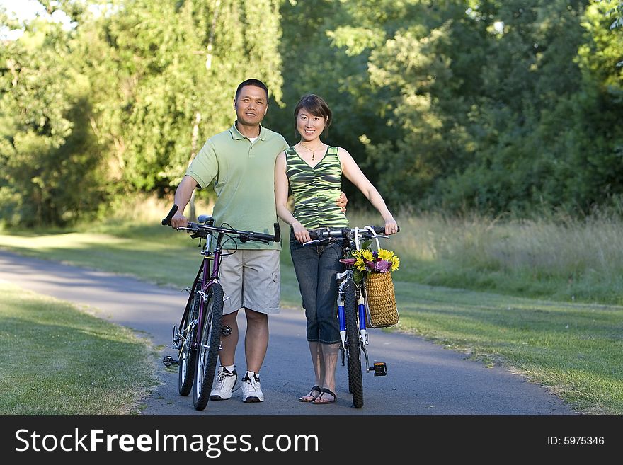 Couple Stands With Bicycles Smiling - Horizontcal