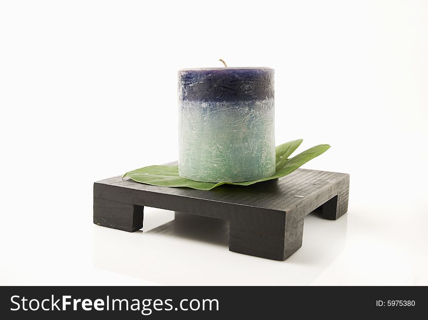 Still life of candle and leaf on wooden candlestand. Still life of candle and leaf on wooden candlestand