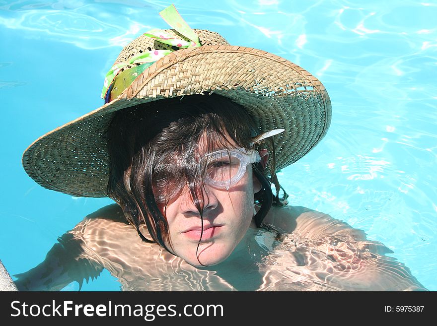 Boy in water with a goofy hat and goggles. Boy in water with a goofy hat and goggles.