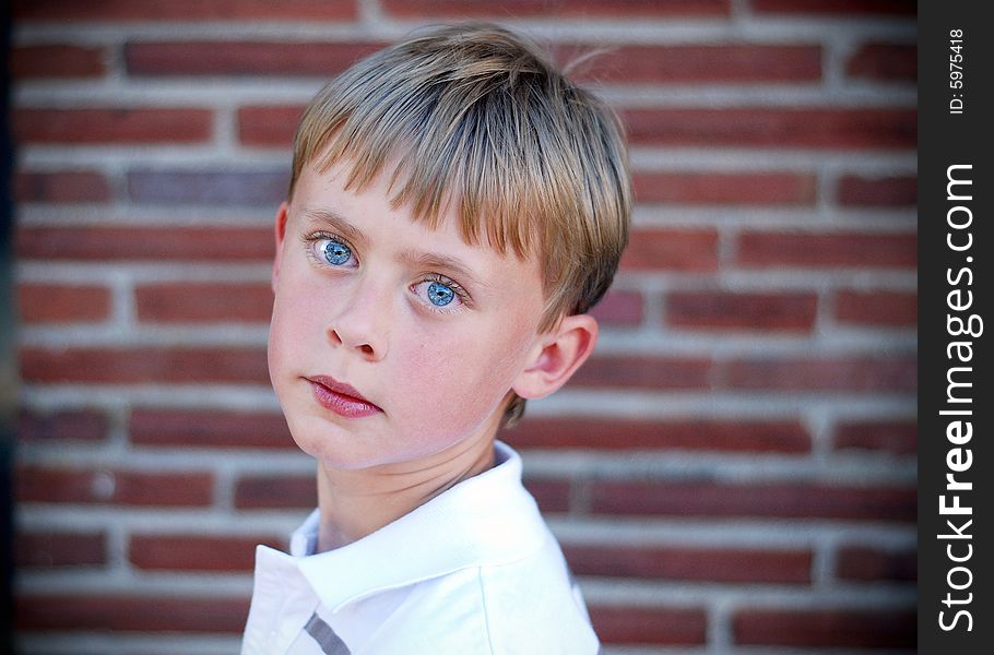 Boy Standing Against Brick Wall - Horizontal