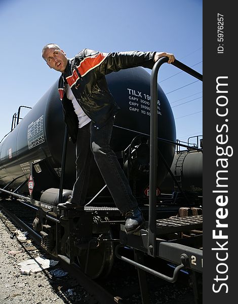 Male fashion model posing outdoors on a train. Male fashion model posing outdoors on a train