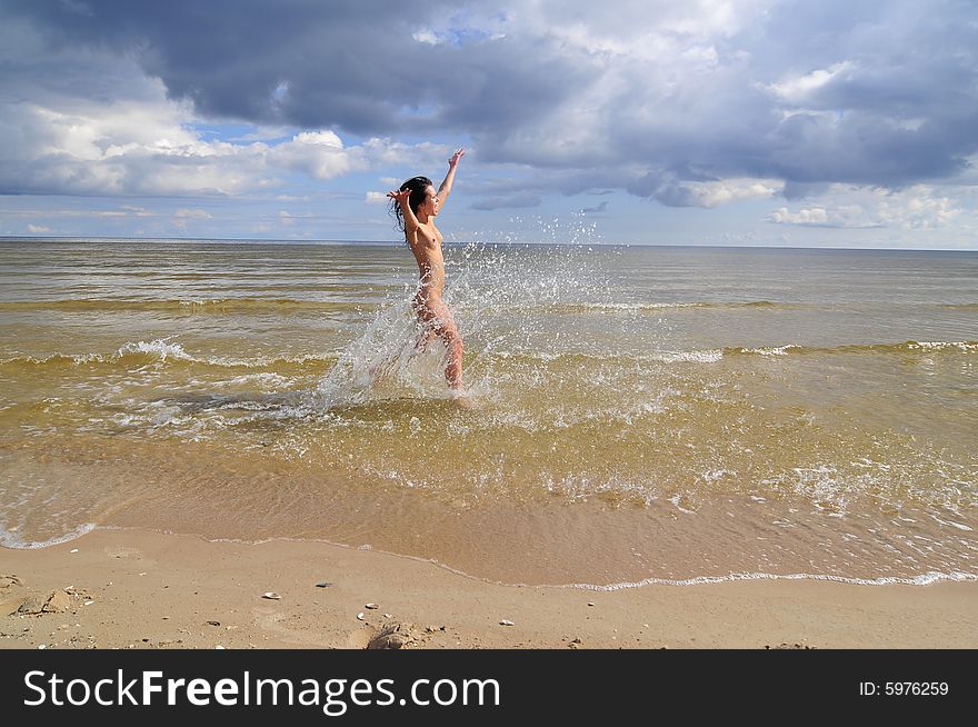 Naked girl running on the beach