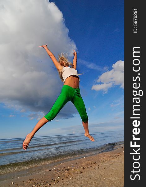 Jumping girl on a backgground of a blue sky