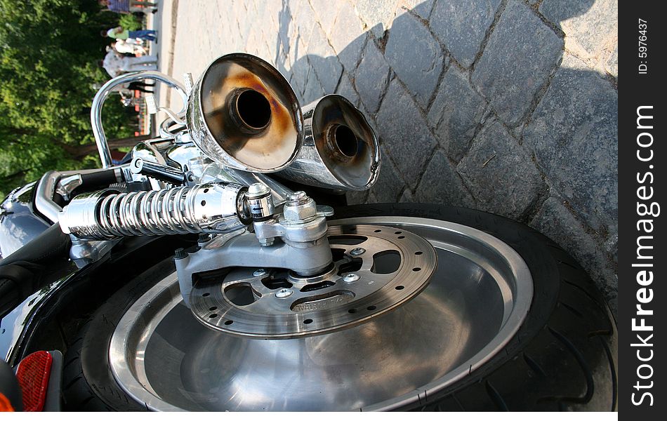 Close-up exhaust pipes and wheel of the chromeplated motorcycle. Close-up exhaust pipes and wheel of the chromeplated motorcycle