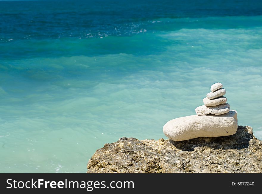 Stacked limestone pebbles on the beach, blurred background. Stacked limestone pebbles on the beach, blurred background