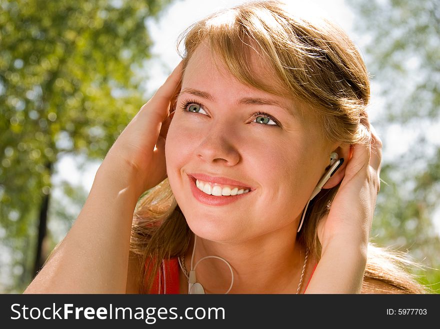 Girl listening to the music in the park