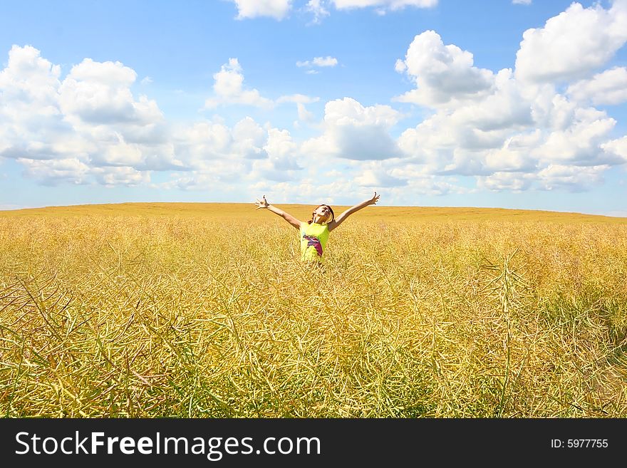 Happy young girl relaxing on yellow meadow