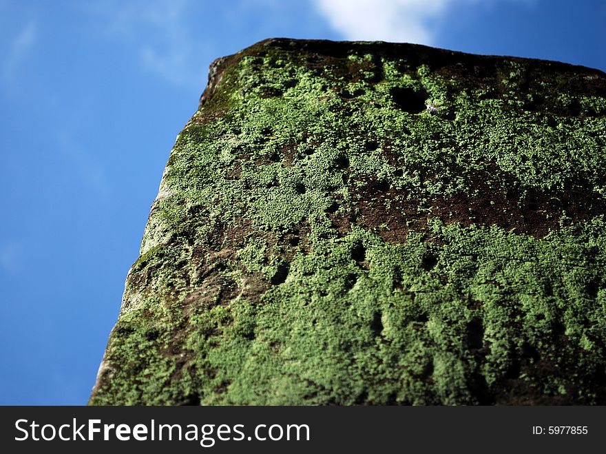 A mossy stone pillar at the historical place in Cambodia