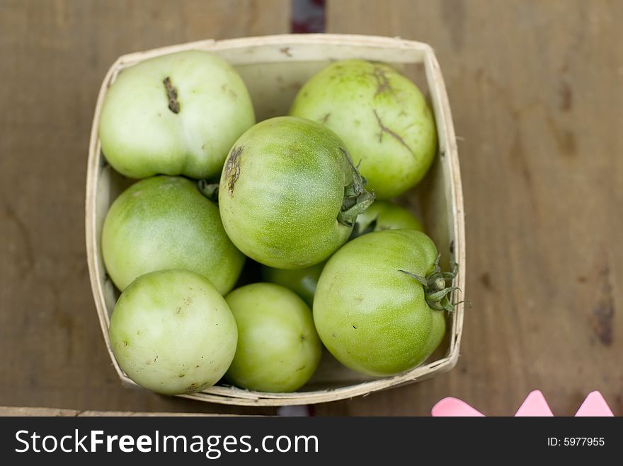 Pale green tomatoes in a wooden crate. Pale green tomatoes in a wooden crate.