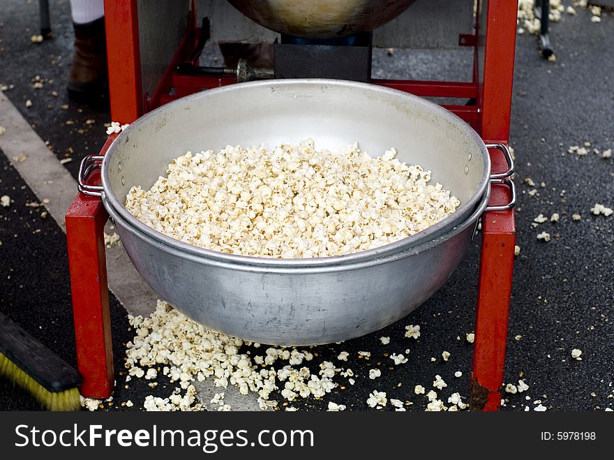 A tin basin filled with kettle corn at a county fair. A tin basin filled with kettle corn at a county fair.