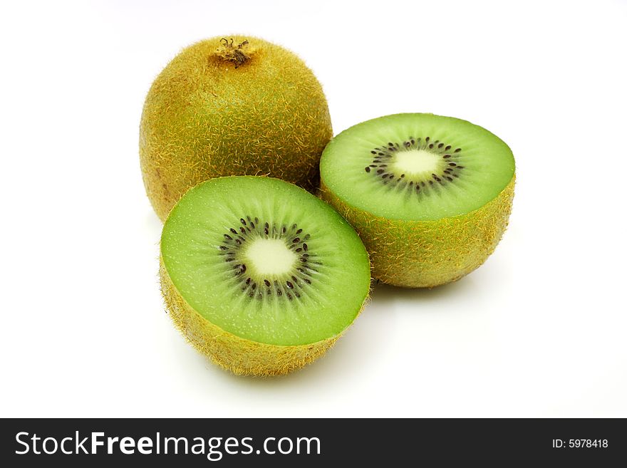A kiwi fruit sliced into half with the fullness one on white background. A kiwi fruit sliced into half with the fullness one on white background.