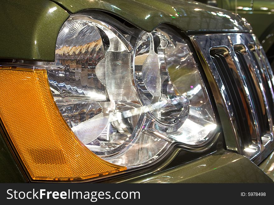 Close-up of a new modern car: head lamp and radiator. Close-up of a new modern car: head lamp and radiator