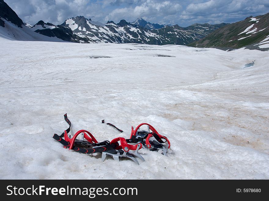 Crampon on snow with mountains on the background