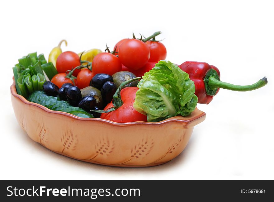 A bowl full of fresh and pickled vegetables isolated on white. A bowl full of fresh and pickled vegetables isolated on white.