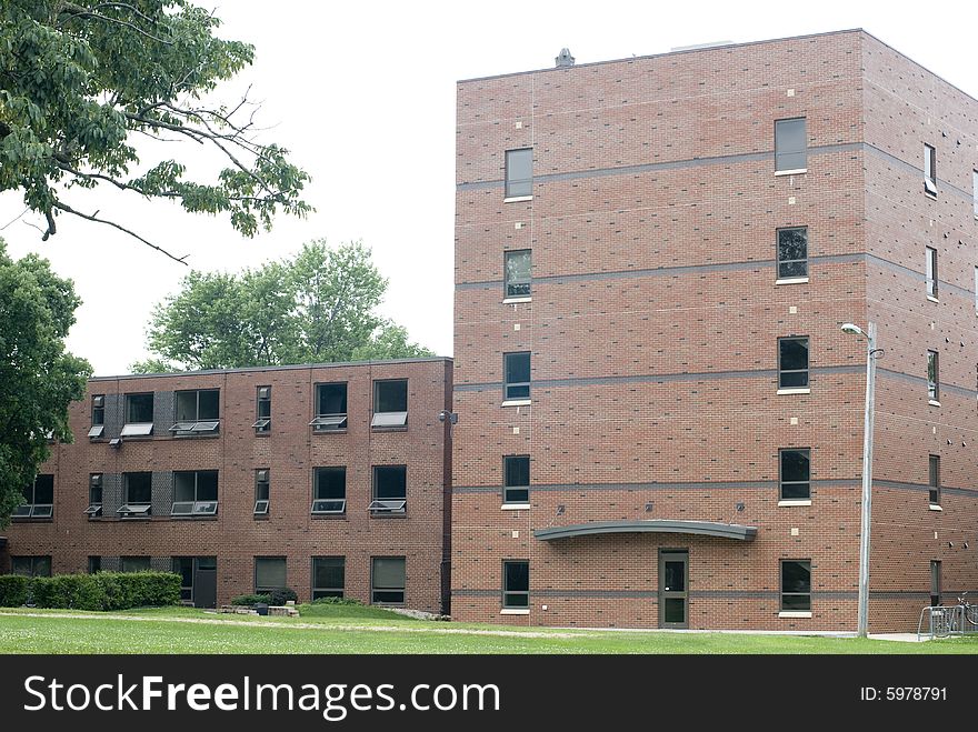 An exterior shot of a brick dormitory building. An exterior shot of a brick dormitory building.