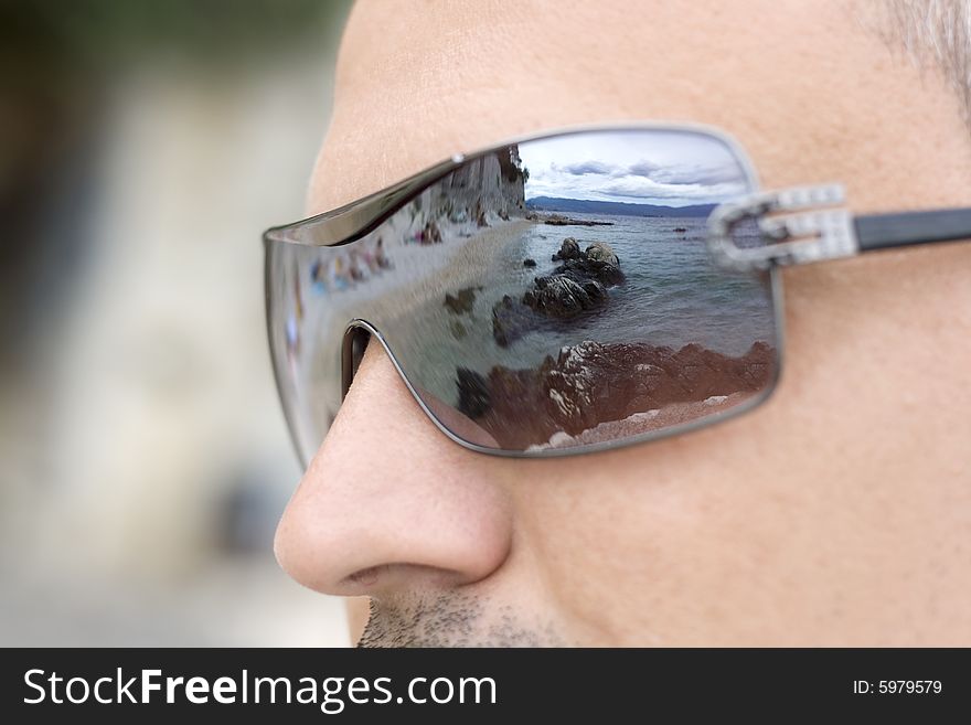 A reflection of a coastal landscape in the sunglasses. A reflection of a coastal landscape in the sunglasses