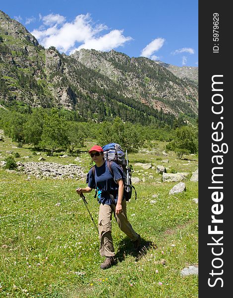 Backpacker girl walking in mountains