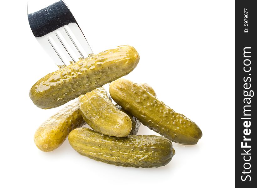 Crackling pickled gherkins on a plug on a white background