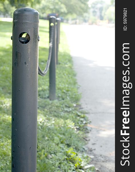 Closeup of black iron posts connected by a chain link.