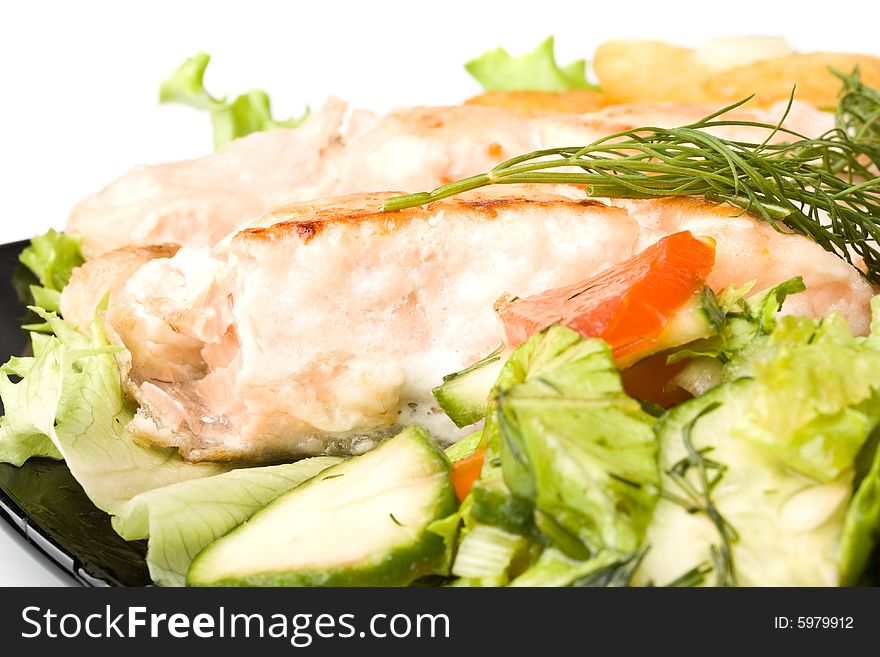 Stake from a salmon with vegetables on a plate. Closeup.