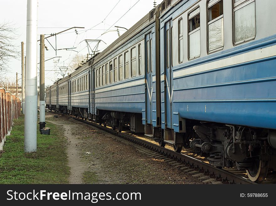 Blue suburban train moves diagonally in the picture. Blue suburban train moves diagonally in the picture