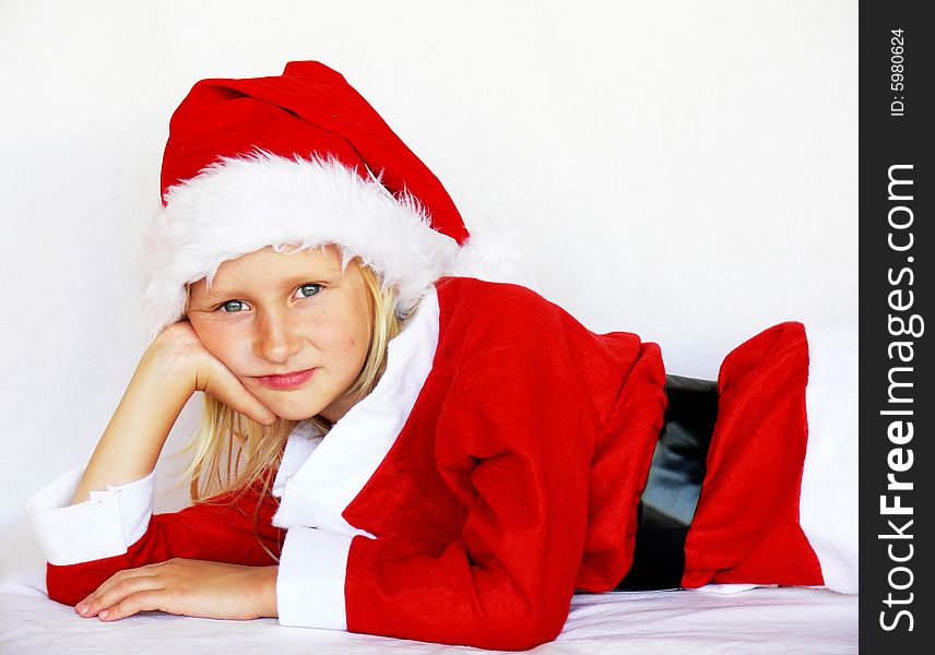 An adorable girl is lying and wearing a santa dress. An adorable girl is lying and wearing a santa dress.