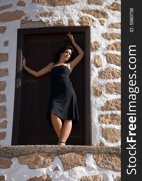 Young beautiful woman posing on a old windmill. Young beautiful woman posing on a old windmill