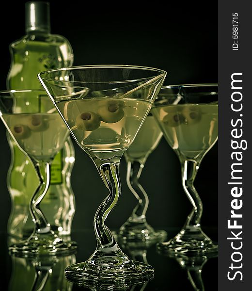 Martini glasses with olives shot on a  dark field. Martini glasses with olives shot on a  dark field