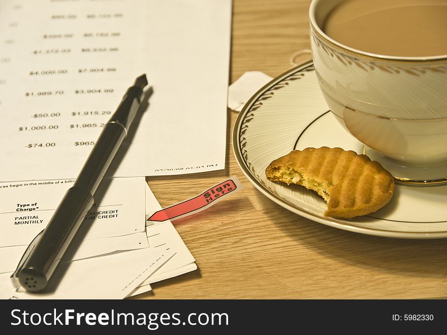 Pen, cup of tea, cookie with documents to sign. Pen, cup of tea, cookie with documents to sign