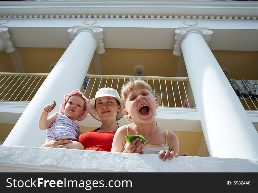 Mother and her two daughters near a large house with columns. Mother and her two daughters near a large house with columns