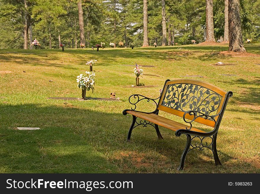 A bench overlooking a grave in a cemeteray. A bench overlooking a grave in a cemeteray