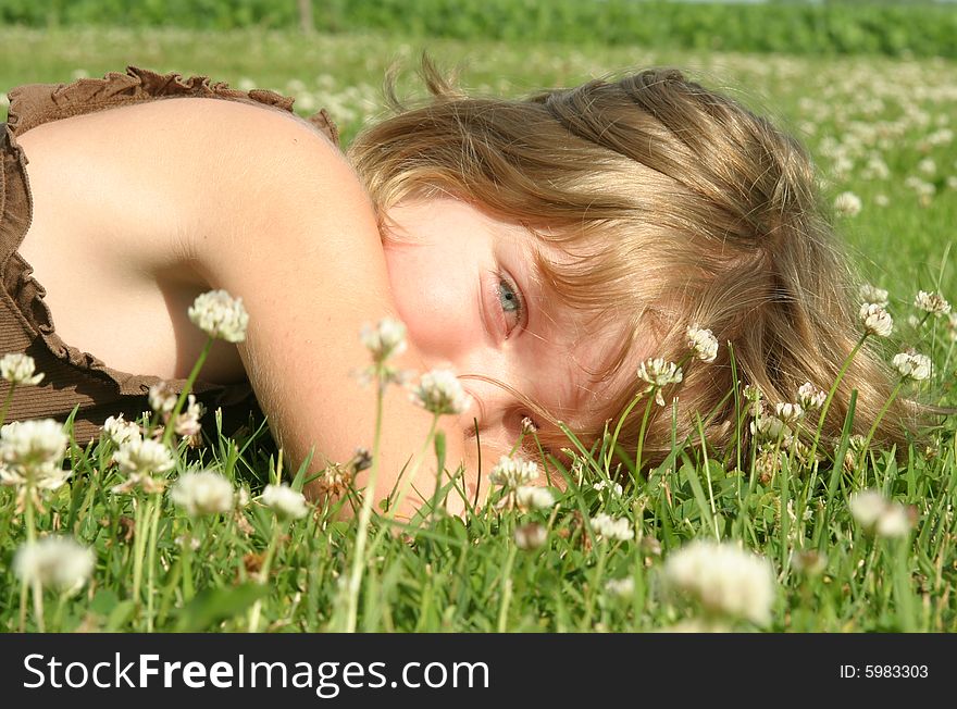 Young girl laying in a field of grass and wild flowers. Young girl laying in a field of grass and wild flowers