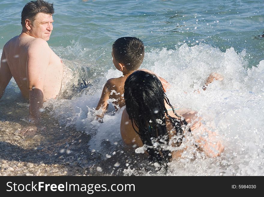 Woman, man and boy on the beach in summer