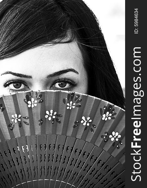 Spanish woman behind traditional fan. Spanish woman behind traditional fan.