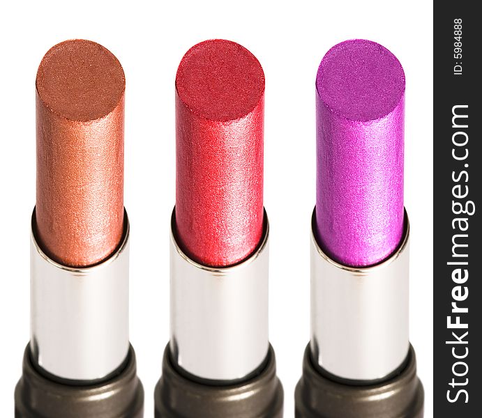 Three colored lipsticks on white background