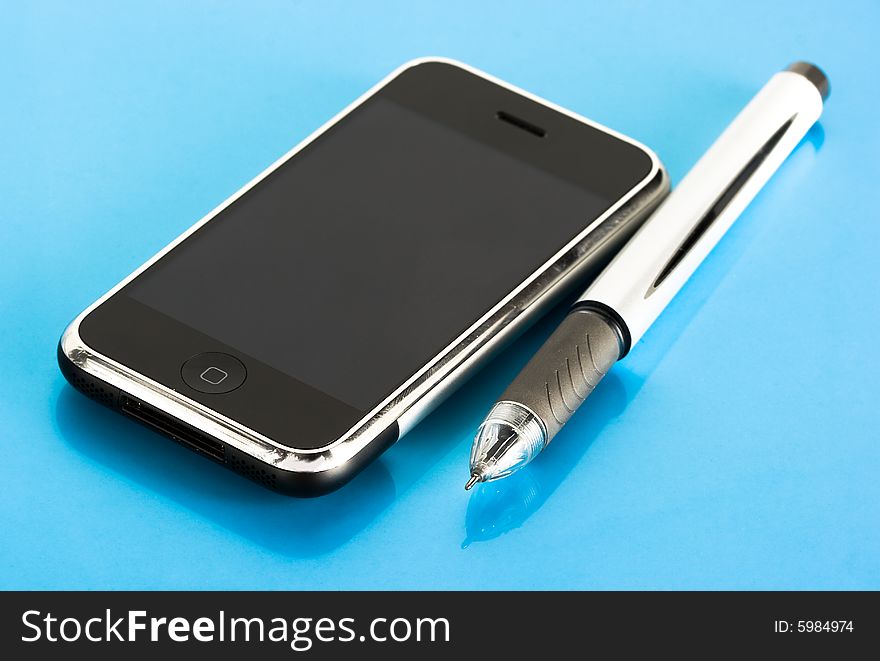 Pen and mobile phone on blue background. Pen and mobile phone on blue background