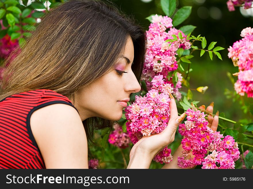 Beautiful girl smells pink flowers
