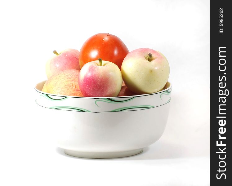 Apples and tomato  in a bowl on white background