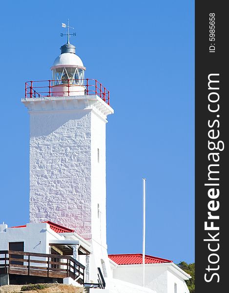 A newly renovated lighthouse and weather station against a bright blue sky.