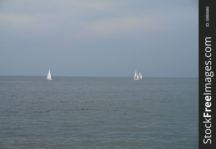 Three sail boats drift apart from one another. Three sail boats drift apart from one another.